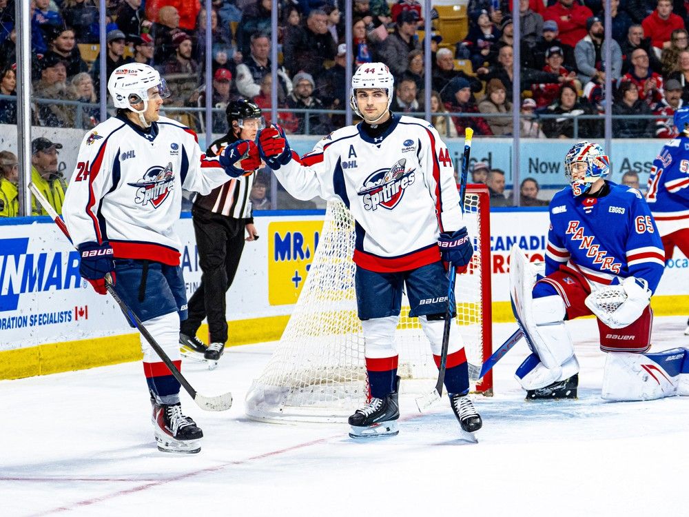 The Windsor Spitfires' Anthony Cristoforo, centre, celebrates his power-play goal with teammate Carson Woodall during Friday's game at the Memorial Auditorium in Kitchener.
