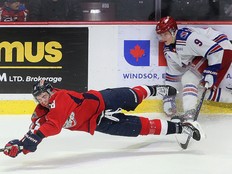 Windsor Spitfires' forward A.J. Spellacy gets tripped up by the Kitchener Rangers' Avry Anstis on Wednesday.