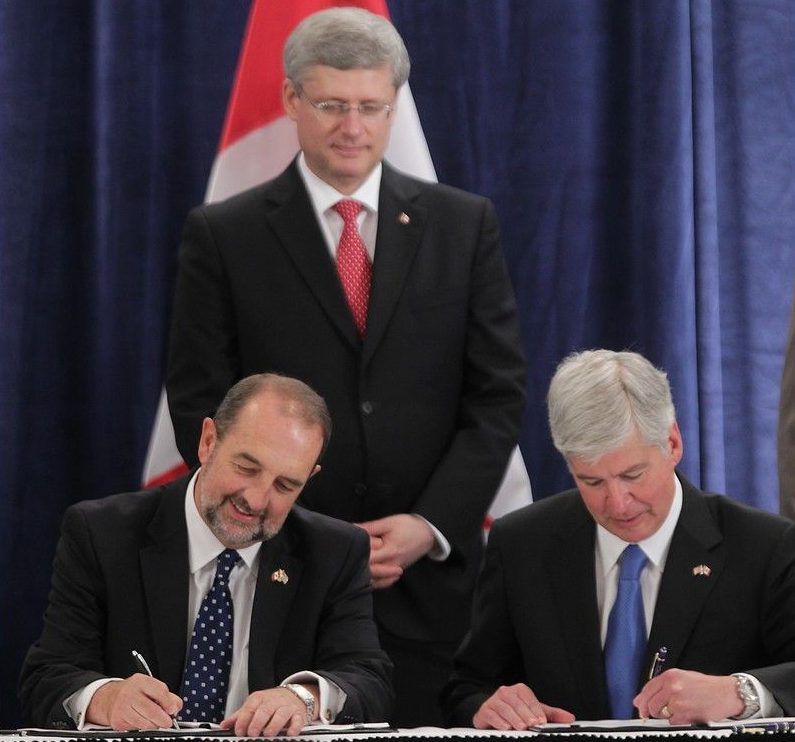  Michigan Gov. Rick Snyder, right, and Denis Lebel, Canadian minister of transport, infrastructure and communities, sign an agreement to build a new Windsor-Detroit bridge as Canadian Prime Minister Stephen Harper looks on during a signing event in Detroit on June 15, 2012.