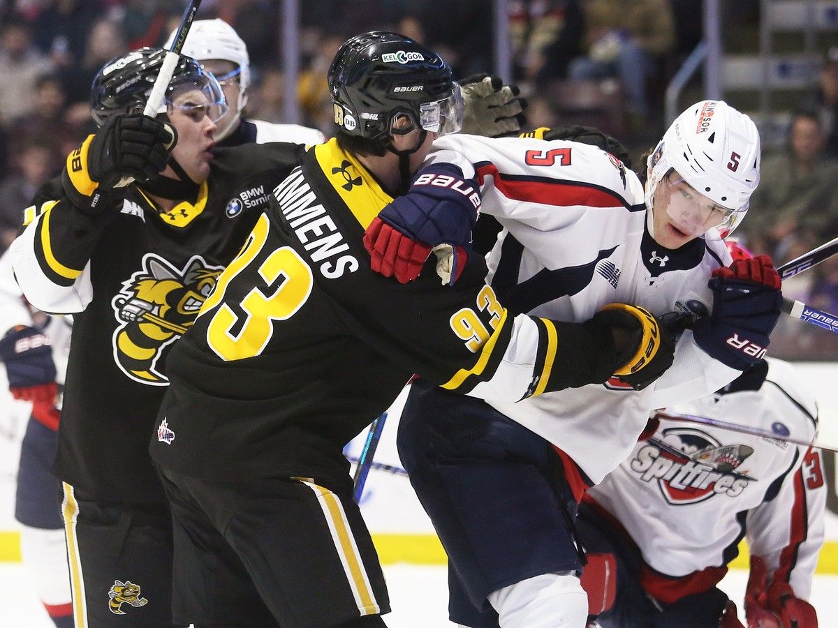 Windsor Spitfires' defenceman Jonathan Brown (5) is grabbed by Sarnia Sting forward Brenner Lammens (93) during Friday's game at the Progressive Auto Sales Arena.