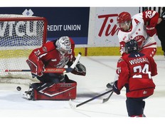 Sault Ste. Marie Greyhounds's forward Marco Mignosa scores the game-winning goal in overtime on Windsor Spitfires' goalie Joey Costanzo as teammate Carson Woodall looks on at the WFCU Centre on Thursday.
