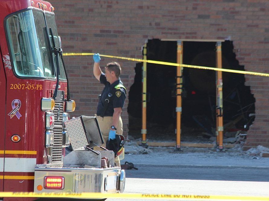 A London firefighter holds police tape outside Sherwood Forest Mall in London after an SUV crashed through a wall into a GoodLife Fitness gym on Friday, June 12, 2026, injuring seven people. (Dale Carruthers/The London Free Press)