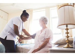 A nurse checks a female patient's blood pressure.