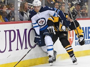 Nikolaj Ehlers of the Winnipeg Jets battles for a puck along the boards with Chad Ruhwedel of the Pittsburgh Penguins on Thursday in Pittsburgh.