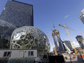 In this Wednesday, Oct. 11, 2017, photo, large spheres take shape in front of an existing Amazon building, behind, as new construction continues across the street in Seattle. Memo to the many places vying for Amazon's second headquarters: It ain't all food trucks and free bananas. For years now, much of downtown Seattle has been a maze of broken streets and caution-taped sidewalks, with dozens of enormous cranes towering overhead as construction trucks rumble past pedestrians and bicyclists. And while Amazon is far from solely to blame for these issues, and many say the benefits clearly outweigh the drawbacks, life has been disrupted. (AP Photo/Elaine Thompson) ORG XMIT: WAET304

WEDNESDAY, OCT. 11, 2017, PHOTO
Elaine Thompson, AP