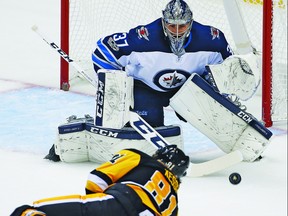 Pittsburgh Penguins' Phil Kessel (81) gets off a shot in front of Winnipeg Jets goalie Connor Hellebuyck (37) in the first period of an NHL hockey game in Pittsburgh, Thursday, Oct. 26, 2017. Hellebuyck made a glove save on the shot but was beaten by Kessel in overtime. (AP Photo/Gene J. Puskar)