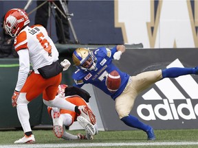 BC Lions' Anthony Thompson (8) and T.J. Lee (6) stop Winnipeg Blue Bombers' Weston Dressler (7) from holding onto the touchdown pass during the first half Saturday.