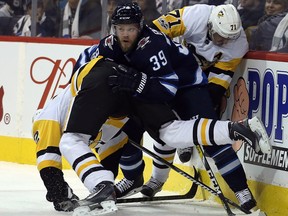 Winnipeg Jets defenceman Tobias Enstrom gets caught between Carl Hagelin (left) and Evgeny Malkin of the Pittsburgh Penguins in Winnipeg on Sun., Oct. 29, 2017.