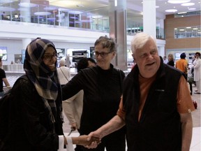 Tom Denton (right) and Karin Gordon (centre) meet a refugee at the Winnipeg International Airport in this screengrab from the documentary While We Can: The Road to Rescue.