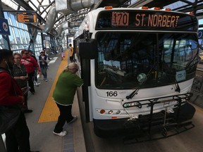 People board a Winnipeg Transit bus along the Southwest Transitway at Osborne Station.