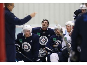 Goaltender Connor Hellebuyck listens to head coach Paul Maurice during Winnipeg Jets practice at Bell MTS Iceplex in Winnipeg on Monday.