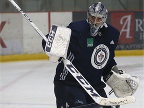 Goaltender Connor Hellebuyck blocks a shot during Winnipeg Jets practice at Bell MTS Iceplex in Winnipeg on Monday.