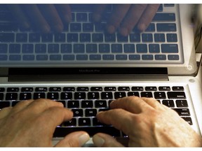 In this Feb. 27, 2013, file photo, hands type on a computer keyboard