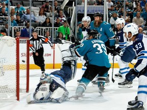 Logan Couture (39) of the San Jose Sharks get the puck by Winnipeg Jets goalie Steve Mason to score a first period goal in San Jose on Saturday. Mason left Saturday’s game after the first period with an upper-body injury after taking a slapper off the mask.