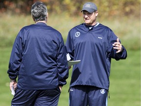 Argos head coach Jim Barker (left) talks with then-special teams coach Mike O'Shea in 2010. Barker gave O'Shea his first job as a CFL coach.