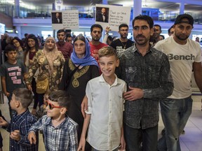 Emad Mishko Tamo, 12-year-old , centre, stands with uncle Hadji Tamo and his mother Nofa Mihlo Rafo as he's reunited with friends and family at Winnipeg's James Armstrong Richardson International Airport Thursday, August 17, 2017. Immigration department officials say a goal of resettling 1,200 survivors of violence at the hands of Islamic militants by year end is within reach. THE CANADIAN PRESS/David Lipnowski