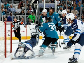 Logan Couture #39 of the San Jose Sharks get the puck by Steve Mason #35 of the Winnipeg Jets to score a first period goal at SAP Center on Saturday in San Jose.(Photo by Don Smith/NHLI via Getty Images)