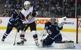 Jets goaltender Connor Hellebuyck makes a glove save in front of Phoenix Coyotes forward Christian Fischer last night in Winnipeg. (Kevin King/Winnipeg Sun)