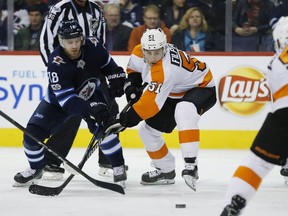 Winnipeg Jets' Bryan Little (18) and Philadelphia Flyers' Valtteri Filppula (51) fight for the puck off the face-off during NHL action in Winnipeg on Thursday.