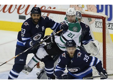 Winnipeg Jets' Dustin Byfuglien (33) attempts to clear Dallas Stars' Antoine Roussel (21) from in front of goaltender Connor Hellebuyck (37) as Toby Enstrom (39) defends during first period NHL action in Winnipeg on Thursday, November 2, 2017. THE CANADIAN PRESS/John Woods ORG XMIT: JGW103
JOHN WOODS,