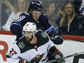 Winnipeg Jets' Brendan Lemieux (48) and Minnesota Wild's Kyle Quincey (27) collide during NHL action in Winnipeg on Friday, Oct. 20.