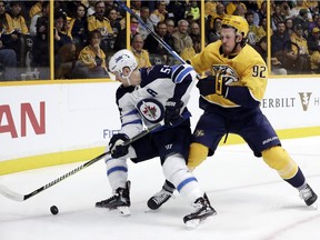 Jets center Mark Scheifele (55) and Nashville Predators center Ryan Johansen (92) battle for the puck in the first period of an NHL game Monday, Nov. 20, in Nashville, Tenn.