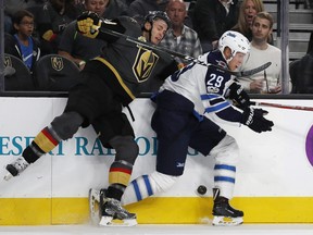 Vegas Golden Knights defenseman Brayden McNabb, left, and Winnipeg Jets right wing Patrik Laine compete for the puck during the first period of an NHL hockey game Friday, Nov. 10, 2017, in Las Vegas.