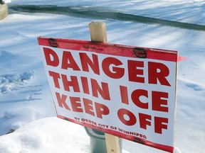A thin ice sign is seen near open water on the Assiniboine River at The Forks in Winnipeg, Man. Monday Jan. 4, 2016.