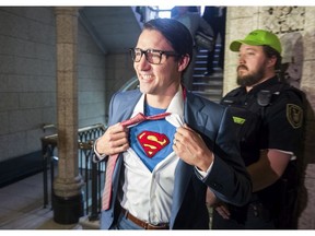 Prime Minister Justin Trudeau shows off his costume as Clark Kent, alter ego of comic book superhero Superman, as he walks through the House of Commons, in Ottawa on Tuesday, Oct. 31, 2017. THE CANADIAN PRESS/Adrian Wyld
