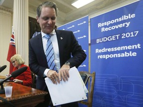 Manitoba Finance Minister Cameron Friesen leaves after speaking to media at a press conference before the provincial budget is read at the Manitoba Legislature in Winnipeg, Tuesday, April 11, 2017. THE CANADIAN PRESS/John Woods