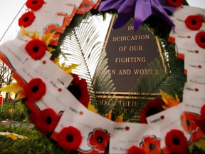 A wreath adorned with poppies frame a monument honouring veterans on Thursday Nov. 10, 2016 at Little Lake Cemetery in Peterborough, Ont. (Clifford Skarstedt/Postmedia Network)