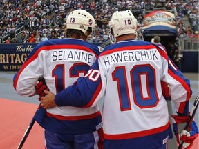 Winnipeg Jets forwards Teemu Selanne (left) and Dale Hawerchuk talk as they leave the ice after the second period of the 2016 Heritage Classic alumni game against the Edmonton Oilers.