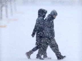 Two people walk in heavy snow close to Polo Park, in Winnipeg. Saturday. A snowfall warning was issued Saturday morning for much of southern Manitoba including the city of Winnipeg.