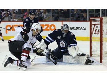 Winnipeg Jets goaltender Connor Hellebuyck looks behind him as Phoenix Coyotes forward Brendan Perlini looks for a rebound in Winnipeg on Tues., Nov. 14, 2017. Kevin King/Winnipeg Sun/Postmedia Network
Kevin King, Kevin King/Winnipeg Sun