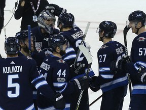 Winnipeg Jets goaltender Connor Hellebuyck (top left) is congratulated by teammates after the Jets beat the Phoenix Coyotes in Winnipeg on Tues., Nov. 14, 2017. Kevin King/Winnipeg Sun/Postmedia Network
Kevin King, Kevin King/Winnipeg Sun