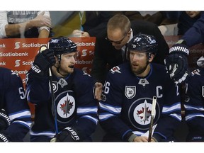 Winnipeg Jets head coach Paul Maurice talks to players on the bench during a break in action.
