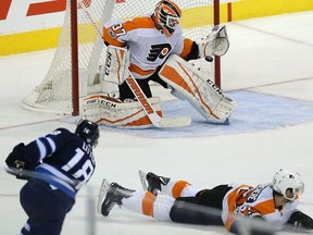 Philadelphia Flyers goaltender Brian Elliott gets enough of a shot from Winnipeg Jets centre Bryan Little during overtime in Winnipeg on Thurs., Nov. 16, 2017. Kevin King/Winnipeg Sun/Postmedia Network
Kevin King, Kevin King/Winnipeg Sun