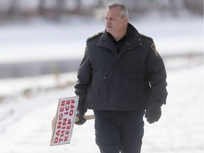 Ray Duma of the Winnipeg Police Service River Patrol Unit walks along the River Walk, near The Forks, Tuesday. Winnipeggers are being advised to stay off the ice.