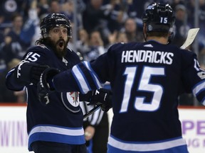 Winnipeg Jets forward Mathieu Perreault (left) celebrates his second-period goal against the Minnesota Wild with Matt Hendricks on Monday.