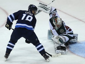 Winnipeg Jets centre Bryan Little tips a puck past Minnesota Wild goaltender Alex Stalock. (Kevin King/Winnipeg Sun/Postmedia Network)