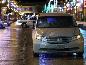 Police hold the scene where a damaged Honda Odyssey sits on eastbound Portage Avenue near Edmonton Street on Monday.