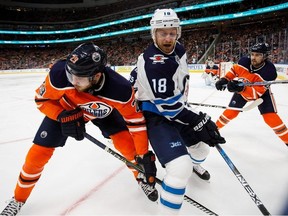 Leon Draisaitl #29 of the Edmonton Oilers battles against Bryan Little #18 of the Winnipeg Jets during National Hockey League action at Rogers Place in Edmonton on Sunday, Dec. 31, 2017. (Codie McLachlan/Postmedia)