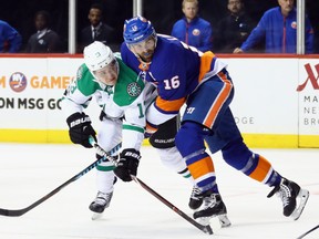 NEW YORK, NY - DECEMBER 13: Mattias Janmark #13 of the Dallas Stars gets off the first period shot as he is held by Andrew Ladd #16 of the New York Islanders at the Barclays Center on December 13, 2017 in the Brooklyn borough of New York City.  (Photo by Bruce Bennett/Getty Images)