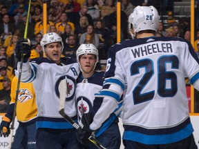 NASHVILLE, TN - DECEMBER 19:  Blake Wheeler #26 and Tyler Myers #57 of the Winnipeg Jets congratulate teammate Mark Scheifele #55 on scoring a goal against the Nashville Predators during the second period at Bridgestone Arena on December 19, 2017 in Nashville, Tennessee.  (Photo by Frederick Breedon/Getty Images)