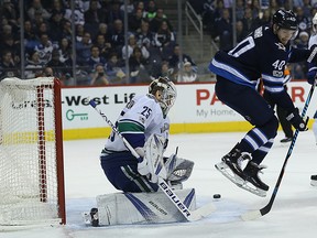 Jets forward Joel Armia jumps as Vancouver Canucks goaltender Jacob Markstrom makes a save at Bell MTS Place on Monday night. (Kevin King/Winnipeg Sun)