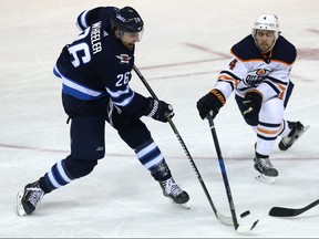 Winnipeg Jets forward Blake Wheeler (left) has his shot blocked by Edmonton Oilers defenceman Kris Russell in Winnipeg on Wed., Dec. 27, 2017. Kevin King/Winnipeg Sun/Postmedia Network