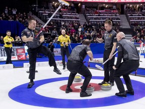 Team Koe lead Ben Hebert throws his broom as he celebrates with second Brent Laing, third Marc Kennedy and Skip Kevin Koe after defeating Team McEwen during the men's final at the 2017 Roar of the Rings Canadian Olympic Curling Trials in Ottawa on Sunday, Dec. 10, 2017. THE CANADIAN PRESS/Justin Tang