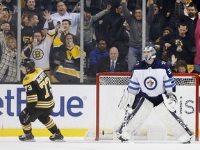Jets goalie Connor Hellebuyck stands in the net after Bruins’ Charlie McAvoy scored the game-winning shootout goal last night. (AP)