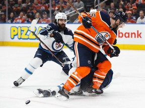 Mark Letestu #55 of the Edmonton Oilers battles with Mathieu Perreault #85 of the Winnipeg Jets during National Hockey League action at Rogers Place in Edmonton on Sunday, Dec. 31, 2017. (Codie McLachlan/Postmedia)