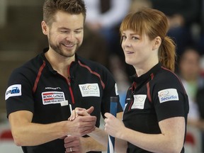 Mixed doubles partners Dawn and Mike McEwen high five after winning an end on Jan. 10, 2015
